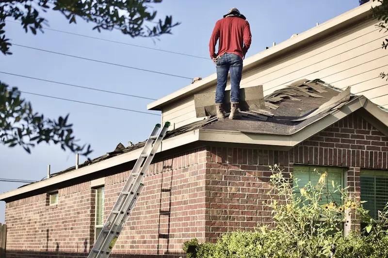Professional roofer working on a residential roof in Leighton